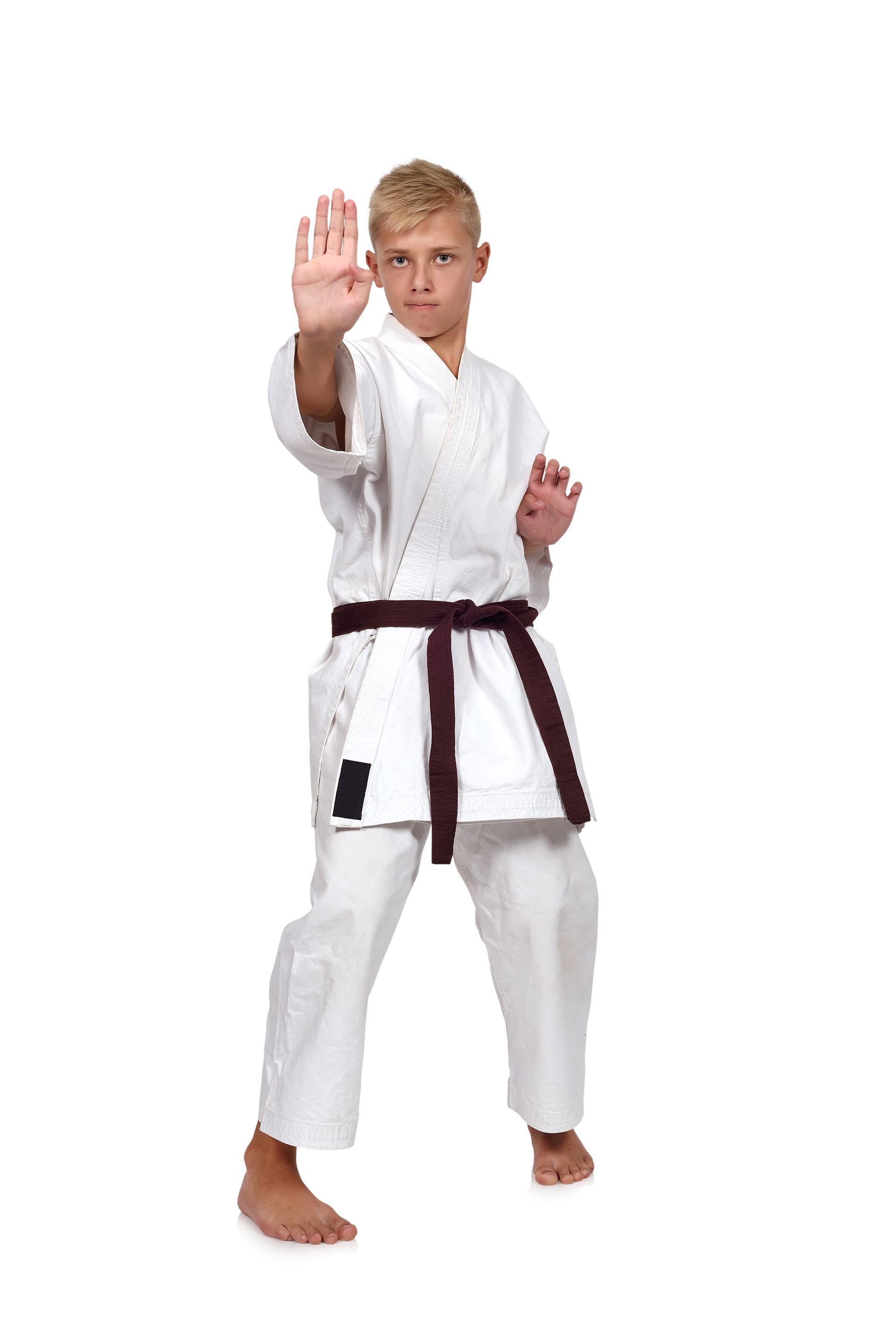 boy in karate suit training on white background
